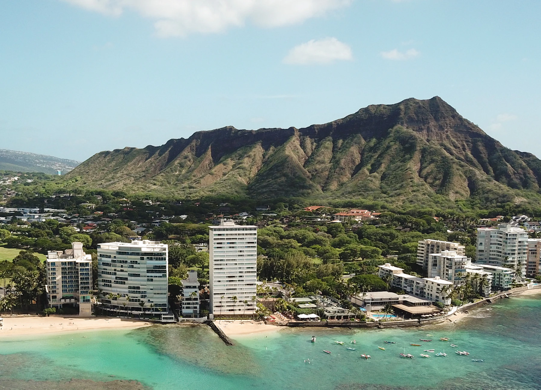 Diamond Head rising behind the beachfront towers and turquoise reef at the Diamond Head end of Waikiki